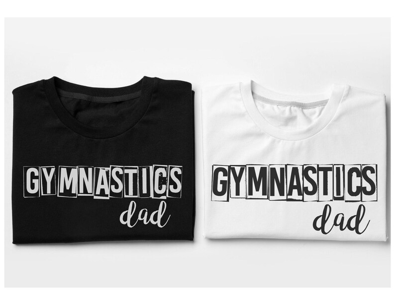 May include: A black t-shirt and a white t-shirt, each featuring the word GYMNASTICS in a block-letter style font with the word dad written in a cursive script underneath. The text on the black shirt is white, and the text on the white shirt is black.