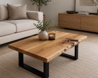 May include: A rectangular coffee table featuring a natural live edge wood slab top with visible grain and a dark resin-filled knot. The table is supported by two sturdy black metal U-shaped legs, providing a stable base for the wooden surface.