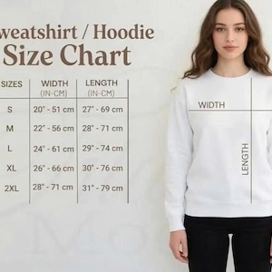 Pu&ograve; includere: Una felpa bianca con una tabella delle taglie. La tabella mostra le taglie dalla S alla 2XL, con misure di larghezza da 51 cm a 71 cm e lunghezze da 69 cm a 79 cm. Una donna indossa la felpa.