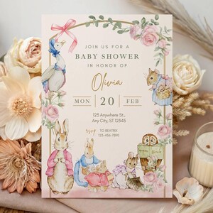 Pode incluir: Convite para chá de bebê com ilustrações de personagens de Peter Rabbit e detalhes florais. O convite inclui o texto "Join us for a Baby Shower in Honor of Olivia" e detalhes do evento.