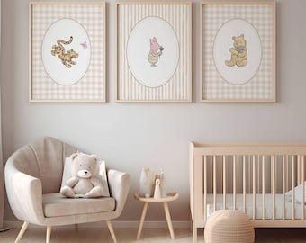 May include: Three framed nursery art prints featuring Winnie the Pooh characters: Tigger, Piglet, and Pooh Bear. Each print has a beige and white background with a cartoon character in an oval frame. The prints are displayed above a chair and crib.