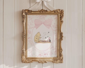 May include: A framed print featuring a Winnie the Pooh illustration with Piglet. The print is in a gold ornate frame, with a pink bow at the top and a white ribbon for hanging. The background has a floral pattern.