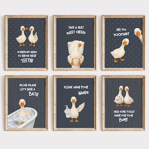 May include: A set of six framed wall art prints featuring white geese in bathroom settings with dark blue backgrounds. The prints include humorous text such as "Take a seat sweet cheeks," "Are you pooping?," and "Please wash your hands" alongside illustrations of geese.