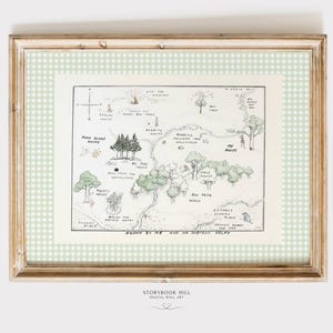 May include: Framed vintage-style map illustration with a light green gingham border. The map, drawn in pencil and watercolor, depicts a whimsical landscape with trees, houses, and text. The frame is a light brown color.