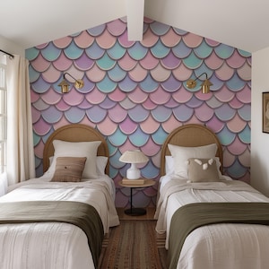 Op de afbeelding: Twee eenpersoonsbedden met houten hoofdeinden en witte beddengoed in een kamer met een muur bedekt met een pastelroze, blauwe en paarse zeemeermin-schubbenbehang.