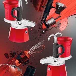Może przedstawiać: Czerwony i srebrny ekspres do kawy z czarnym uchwytem i czerwoną filiżanką. Obraz ma czerwone i czarne abstrakcyjne tło z wybuchającymi częściami ekspresu do kawy.
