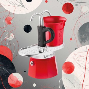 Może przedstawiać: Czerwony ekspres do kawy Mini Express z czarnym uchwytem i srebrnymi akcentami. Czerwony kubek jest umieszczony na g&oacute;rze. Tło przedstawia czerwone, czarne i białe okręgi i linie na szarym gradient.