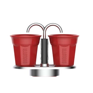 Może przedstawiać: Czerwony zestaw filiżanek do espresso Bialetti ze srebrnym metalowym stojakiem i uchwytem. Filiżanki są cylindryczne z logo Bialetti wydrukowanym z boku. Uchwyt jest czarny, a stojak okrągły.