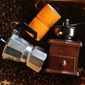 "Manuelle Kaffeemühle, Mokkakanne, Espressotassen - Komplettes Brauset."