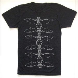 May include: Black t-shirt with a graphic print of a series of bats in a vertical line, with the bats facing each other.