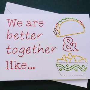 May include: A white card with red embroidery that reads "We are better together like..." with a yellow and green embroidered taco and a bowl of yellow and green embroidered chips.
