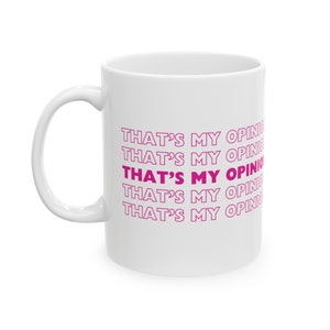May include: White ceramic coffee mug with the phrase "THAT'S MY OPINION" repeated five times in pink.
