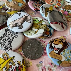 May include: A collection of vintage pinback buttons with various cartoon animal illustrations, including a bear, lion, and elephant. A US quarter is in the center. The buttons are white with colorful designs.