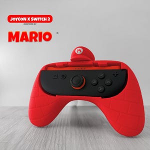 Peut inclure: Coque de manette Joy-Con rouge avec un centre noir, présentant un design sur le thème de Mario. La coque a une surface texturée et comprend un petit détail en forme de chapeau sur le dessus. Le texte "JOYCON X SWITCH 2" et "MARIO" sont visibles.