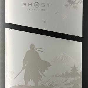 May include: A white rectangular case featuring the silver text Ghost of Tsushima and a graphic of falling maple leaves. Below, a separate white panel displays a silver silhouette of a warrior with a sword, a mountain, and a pagoda in the distance.