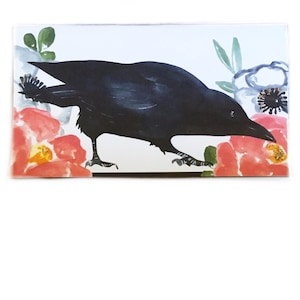 May include: A rectangular art print featuring a black crow with watercolor-style details. The crow is surrounded by red, orange, and blue floral elements on a white background. The artwork has a whimsical and decorative style.