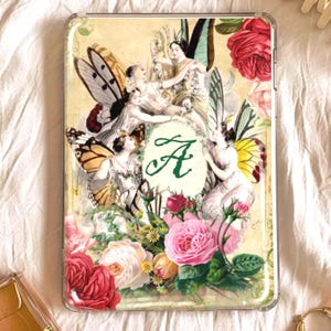 May include: A clear tablet case featuring a vintage-style illustration of fairies with butterfly wings, surrounded by roses and the letter "A". The artwork has a soft, antique aesthetic with a floral and fantasy theme.