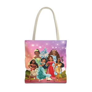Pu&ograve; includere: Una borsa tote con uno sfondo sfumato rosa, viola e blu che presenta un castello e sei principesse Disney. Le principesse indossano i loro abiti caratteristici e hanno la pelle marrone. Le principesse sono in piedi di fronte a un castello con stelle sullo sfondo.