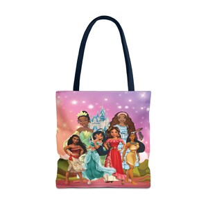 Pu&ograve; includere: Una borsa tote con uno sfondo sfumato rosa e viola che presenta un gruppo di principesse Disney. Le principesse indossano tutte abiti diversi e hanno acconciature diverse. La borsa ha un manico blu scuro.