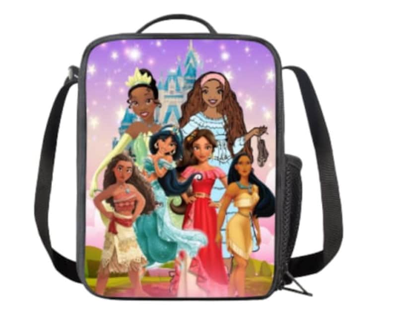 Puede incluir: Una bolsa de almuerzo morada con un estampado colorido de princesas Disney. Las princesas est&aacute;n de pie frente a un castillo rosa con estrellas en el fondo. La bolsa tiene una correa negra.