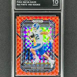 May include: A red, white, and blue football card featuring PUKA NACUA, a Brigham Young University player. The card is graded GEM MINT 10 and is numbered 041/25. The card is part of the 2023 Panini Prizm Draft Picks collection.