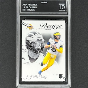 May include: A 2024 Prestige J.J. McCarthy #311 Rookie trading card, graded GEM MINT 10, encased in a protective holder. The card features a color action shot of a football player in yellow and blue, and a black and white portrait.