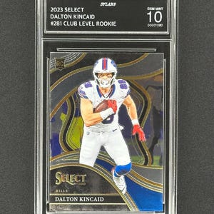 May include: A graded trading card of Dalton Kincaid, a rookie football player for the Buffalo Bills. The card is from the 2023 Select series and is numbered #281. The card is graded Gem Mint 10.