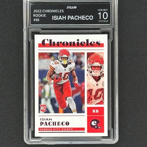 May include: A graded trading card of Isiah Pacheco, a rookie running back for the Kansas City Chiefs. The card is from the 2022 Panini Chronicles series and is graded Gem Mint 10. The card features a photo of Pacheco in his Chiefs uniform, along with his name, team, and position.