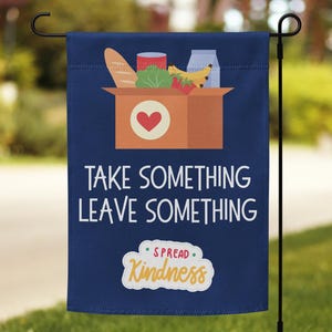 以下が含まれることがあります： 「TAKE SOMETHING LEAVE SOMETHING」と「SPREAD Kindness」の文字が入った、紺色のガーデンフラッグ。赤いハートと食べ物のイラストが入った茶色の箱が特徴です。