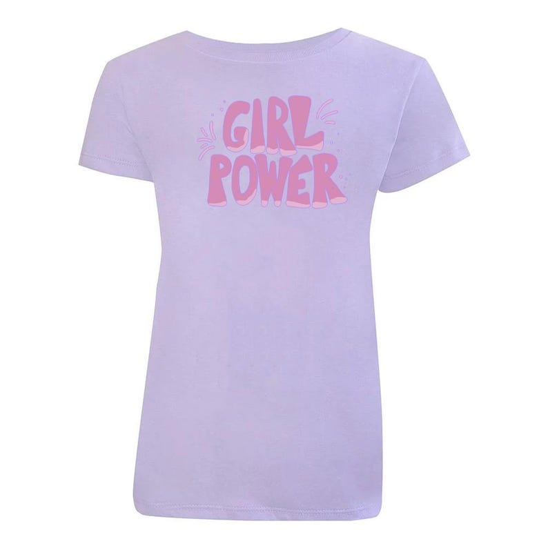 K&ouml;nnte beinhalten: Ein lavendelfarbenes T-Shirt mit einer pinkfarbenen Grafik, auf der in einer verspielten, blasenartigen Schrift "GIRL POWER" steht.