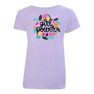 K&ouml;nnte beinhalten: Ein lavendelfarbenes T-Shirt mit einem Blumendesign und dem Text "girl power" in schwarzen Buchstaben.