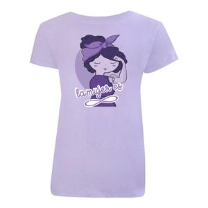 K&ouml;nnte beinhalten: Lilafarbenes T-Shirt mit einer Cartoon-Illustration einer Frau, die die Faust in die Luft reckt. Die Frau tr&auml;gt ein lilafarbenes Stirnband und hat ein lilafarbenes Tattoo auf dem Arm. Der Text "la mujer es" ist unter der Frau in lilafarbener Schrift geschrieben.