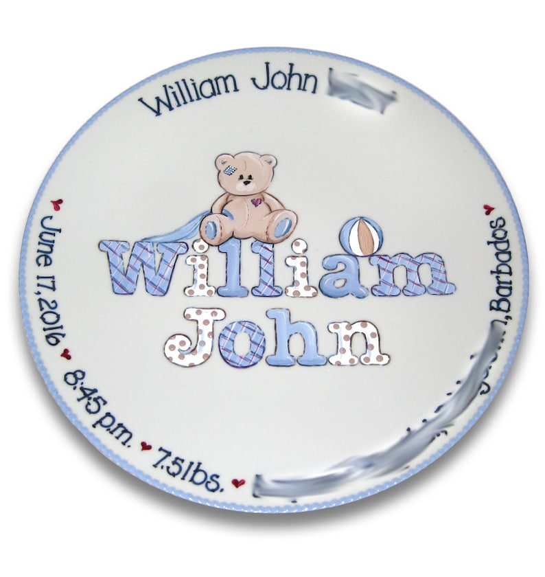 May include: A white ceramic plate with a blue border and a teddy bear design. The plate is personalized with the name "William John", the date "June 17, 2016", the time "8:45 pm", and the weight "7.5 lbs".