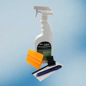 Puede incluir: Una botella de spray blanca etiquetada "ProView Application Solution" con una escobilla amarilla, un cuchillo de uso general azul y un raspador negro.