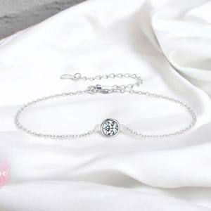 May include: A delicate silver chain bracelet with a single round clear stone in the center.