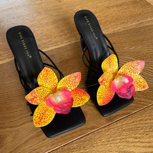 Orange Orchidee schwarze Riemchensandalen
