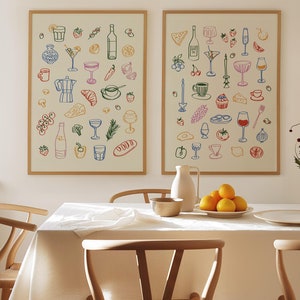 Może przedstawiać: Dwa oprawione ilustracje różnych artykułów spożywczych i napojów, w tym kieliszki do wina, chleb, owoce i filiżanki do kawy. Ilustracje są w minimalistycznym stylu z kolorowymi konturami. Ramy są z jasnego drewna i wiszą na białej ścianie. Biały obrus pokrywa stół z dwoma drewnianymi krzesłami i miską cytryn.