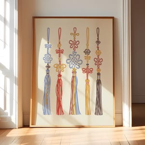 Könnte beinhalten: Gerahmter Druck mit sechs farbenfrohen asiatischen Knotentrossen. Jede Quaste hat ein einzigartiges Design und Farbschema, darunter Blau, Rot, Gelb und Braun. Das Kunstwerk wird auf cremefarbenem Hintergrund mit Holzrahmen gezeigt.