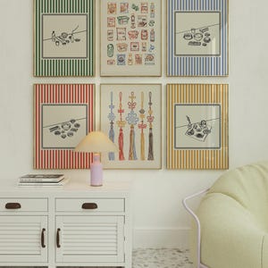 Puede incluir: Una colecci&oacute;n de l&aacute;minas art&iacute;sticas enmarcadas con varios dise&ntilde;os. Las l&aacute;minas presentan dibujos lineales de alimentos, nudos decorativos y otros objetos. Los marcos tienen bordes a rayas de colores en verde, azul, rojo y amarillo. Un mueble blanco con una l&aacute;mpara y una silla est&aacute;n en primer plano.