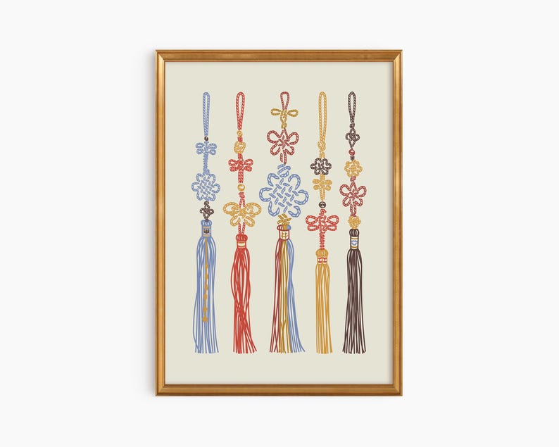 Puede incluir: Una impresi&oacute;n enmarcada con seis adornos de nudos coreanos coloridos. Cada adorno tiene un dise&ntilde;o &uacute;nico y est&aacute; adornado con borlas en tonos de azul, rojo, amarillo y marr&oacute;n. La impresi&oacute;n est&aacute; sobre un fondo crema y enmarcada en oro.