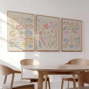 Può includere: Tre illustrazioni incorniciate di cibi. La prima cornice presenta una varietà di formaggi in tonalità di giallo, arancione, rosa e blu. La seconda cornice presenta una varietà di forme di pasta in tonalità di giallo, arancione, rosa e blu. La terza cornice presenta una varietà di forme di pane in tonalità di giallo, arancione, rosa e blu.