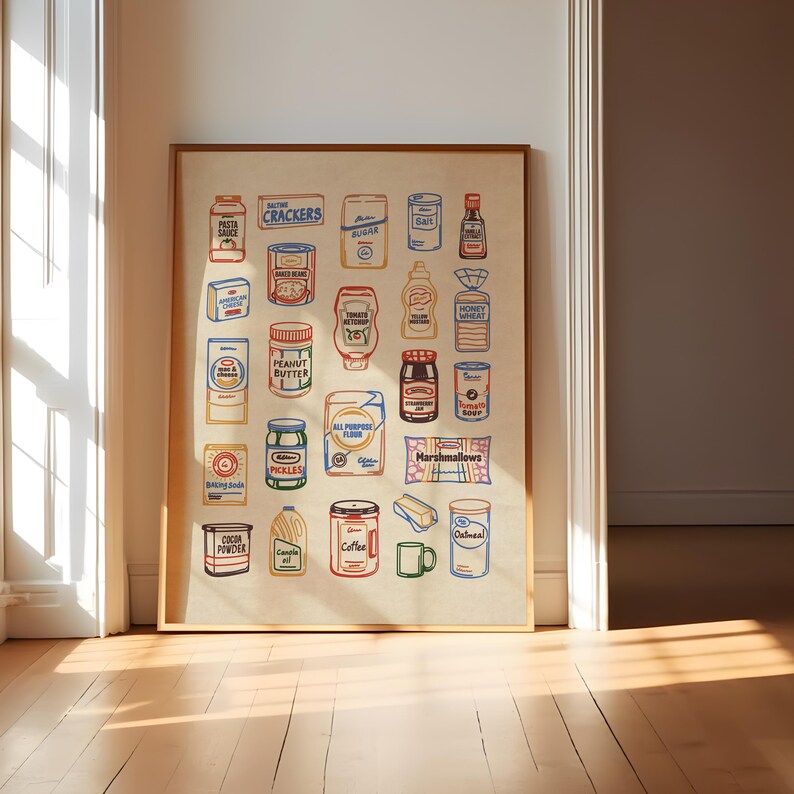 May include: A framed print featuring colorful illustrations of various grocery items, including pasta sauce, crackers, peanut butter, pickles, sugar, salt, ketchup, honey wheat, baking soda, cocoa powder, coffee, and oatmeal. The artwork is displayed on a light beige background.