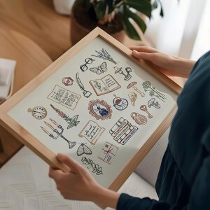 May include: A framed print with a light wood frame featuring a collection of illustrated vintage objects. The illustrations include a pocket watch, books, a quill, a teacup, and a butterfly. The artwork has a cream-colored background.