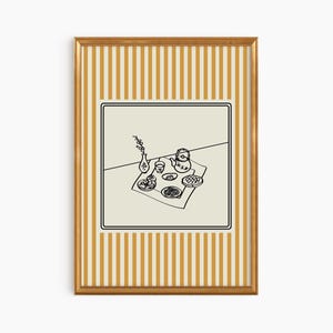 Puede incluir: Una impresi&oacute;n art&iacute;stica enmarcada con una ilustraci&oacute;n en blanco y negro de una mesa puesta. La obra de arte representa una tetera, platos de comida y un jarr&oacute;n con flores. El marco tiene un acabado dorado y un patr&oacute;n de rayas en amarillo y blanco.