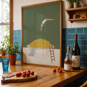 May include: A framed art print depicts a person diving into a bowl of spaghetti. A wooden cutting board with cherries, a blue glass, and two bottles of wine sit on a wooden table. The art print has a wooden frame.