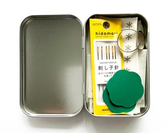 Mini Mend Kit: Sashiko needles, palm thimble, needle pullers, and stick and stitch patterns in a tin.