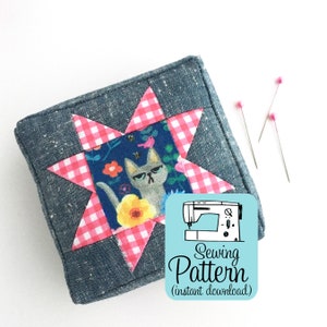 May include: A sewing pattern for a pincushion shaped like a star with a pink and white gingham fabric and a cat print fabric in the center. The pattern is called "Sewing Pattern (instant download)".