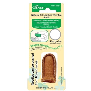 May include: A small, brown leather thimble with a floral design, packaged on a white and green card. The packaging includes text that reads "Natural Fit Leather Thimble Small" and "Needles can be pushed from tip and sides."