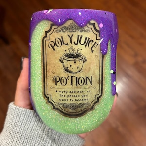 Puede incluir: Un vaso de glitter verde y morado con una etiqueta que dice "Polyjuice Potion" y "Simplemente agrega el cabello de la persona en la que quieres convertirte".