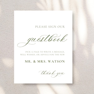 May include: White sign with green text that says "Please sign our guestbook. Pick a page to write a message, well wishes, or advice for the new Mr. & Mrs. Watson. Thank you."